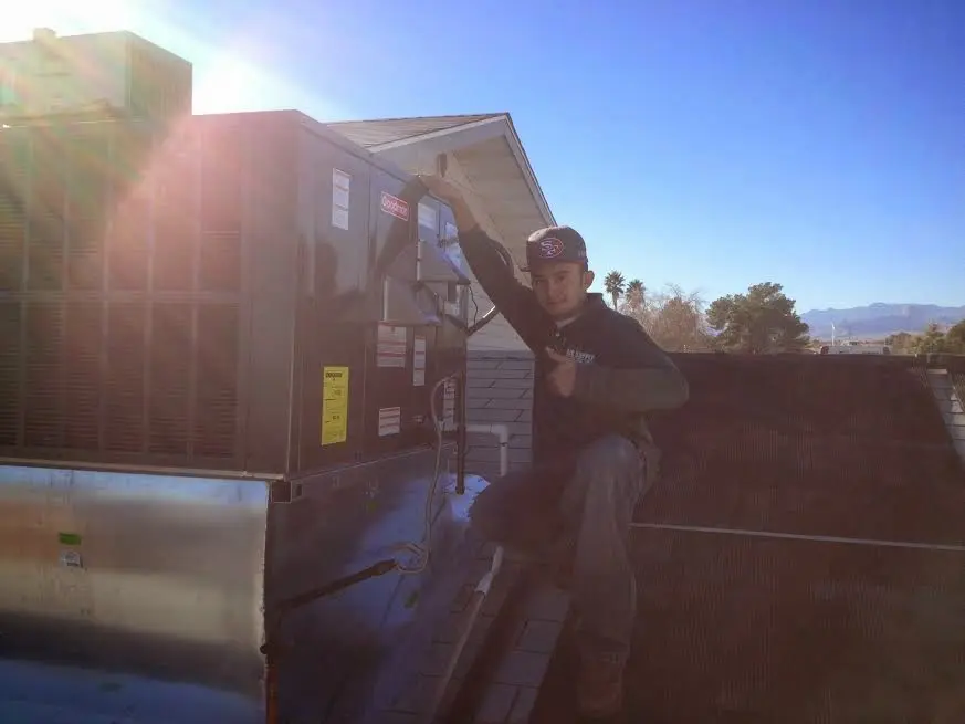 HVAC technician performing AC Tune-Up on a rooftop unit in East Highland Park